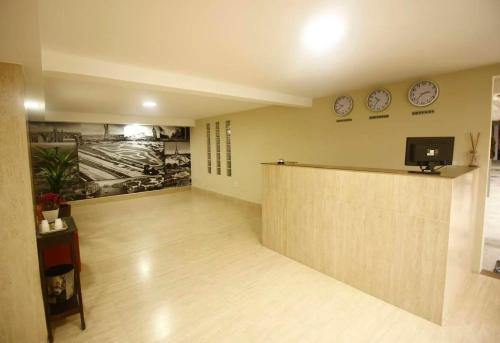 a waiting room with clocks on the wall and a counter at Hotel Interlagos Plaza in São Paulo