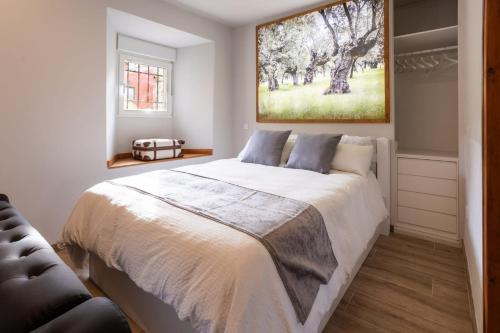 a bedroom with a bed and a painting on the wall at REFUGIO De PERNACIO in Ávila