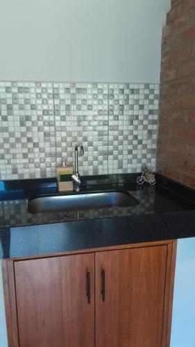 a bathroom sink with a black counter top at Alojamiento LA PERSEA in Encarnación