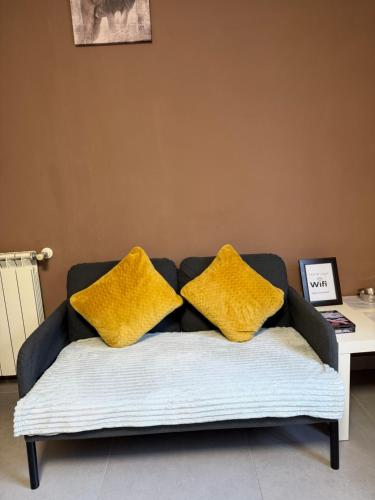 a couch with two yellow pillows on it at Casa da Lagoa in Geres
