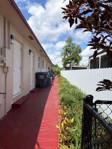 a red sidewalk next to a building with trash cans at Cozy Haven your home away from home in Hollywood