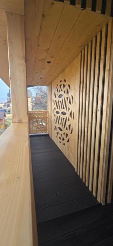 a wooden walkway with a wooden wall with a design on it at Apartament u Krupy z Prywatnym Jacuzzi i tarasem Widokowym in Murzasichle