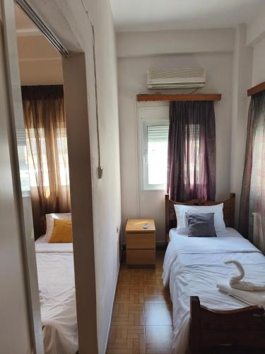 a small bedroom with two beds and a window at Aianteio Square Resort -SPA in Aiándion