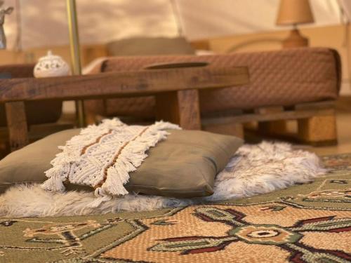 a pillow sitting on top of a rug with a bench at Golden Camp in Falerna