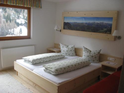 a bedroom with two beds and a large window at Alpenrose-Apart in Nauders