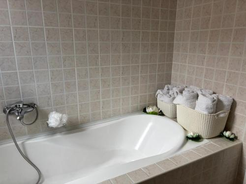 a bath tub with towels in a bathroom at Vila Siana in Mamaia