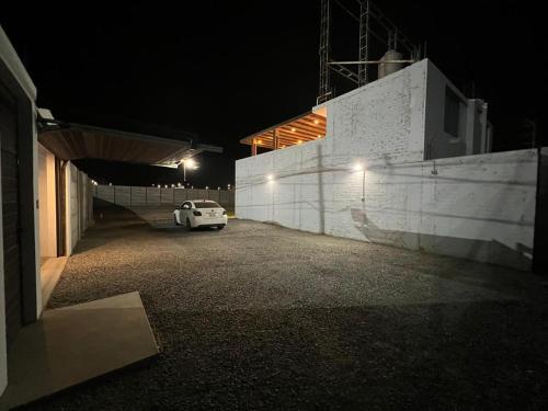 a white car parked in a parking lot at night at Residencia Privé in Ica