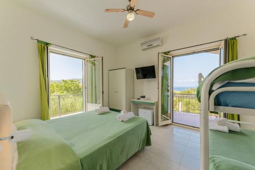a bedroom with a green bed and a balcony at Hotel Ulisse in Palinuro