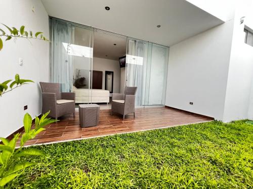 an open living room with glass walls and grass at Residencia Privé in Ica