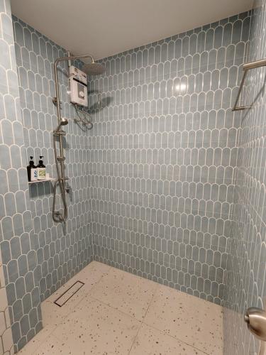 a bathroom with a shower with blue tiled walls at Retrovibes Sathorn BTS Saphan Taksin ICONSIAM Asiatique Chao Phraya Max 9 persons in Bangkok