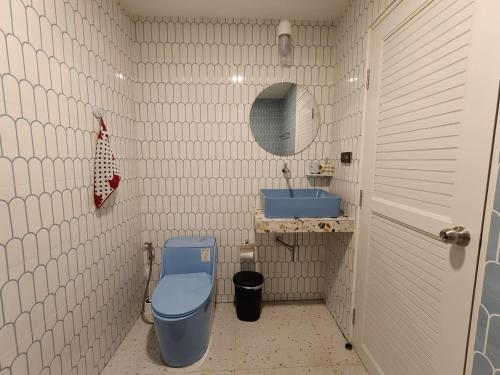 a bathroom with a blue toilet and a sink at Retrovibes Sathorn BTS Saphan Taksin ICONSIAM Asiatique Chao Phraya Max 9 persons in Bangkok