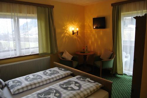 ドルフガシュタインにあるHaus Grütznerのベッド2台とテーブルが備わるホテルルームです。