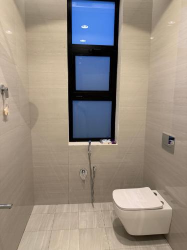a bathroom with a toilet and a window at فلل وشاليهات لفونيا in Buraydah