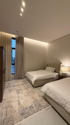 a hotel room with two beds and a window at فلل وشاليهات لفونيا in Buraydah