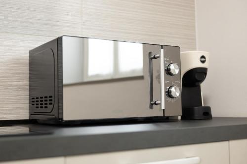 a microwave sitting on top of a counter at Moderno Bilocale Con Parcheggio Privato in Piacenza