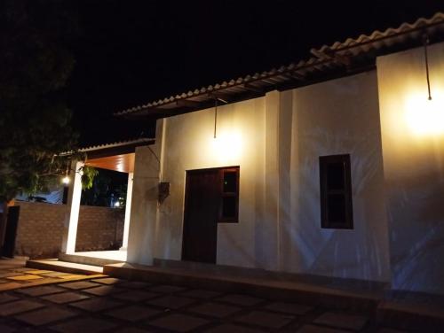 a white building with two windows and a door at night at Cozy Vibe Villa in Arugam Bay