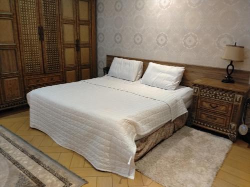 a bedroom with a large white bed and a night stand at Villa Marmara in Medina