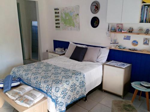 a bedroom with a bed with a blue and white comforter at next to UNISC in Santa Cruz do Sul