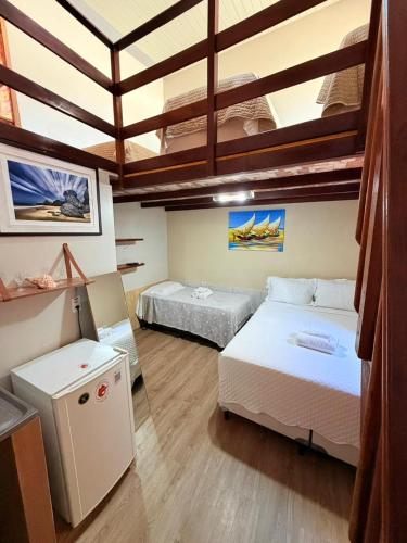 a large room with two beds and a ceiling at Hospedaria Camarão da ilha in Fernando de Noronha