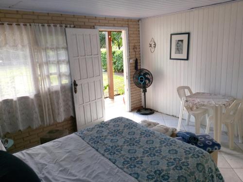 a bedroom with a bed and a table and a fan at next to UNISC in Santa Cruz do Sul