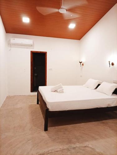 a bedroom with a large bed with a wooden ceiling at Cozy Vibe Villa in Arugam Bay