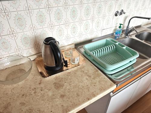 a kitchen counter with a dish drying tray in a sink at Angela Hostel in Fram