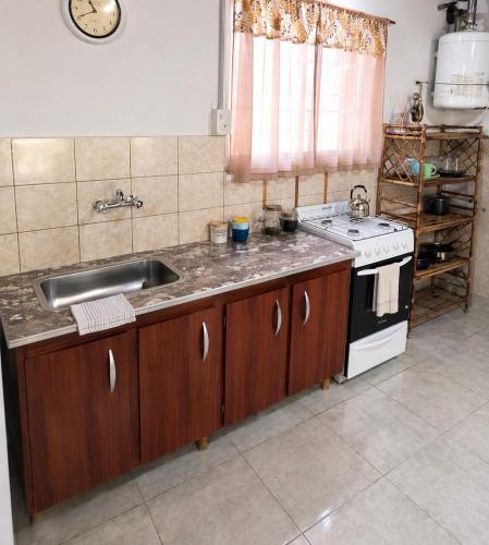 a kitchen with a sink and a stove at Hospedaje Don Felix in General Acha