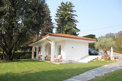 a small white house with a grass yard at Casa Blanca - Villa with pool and private beach in Lesa