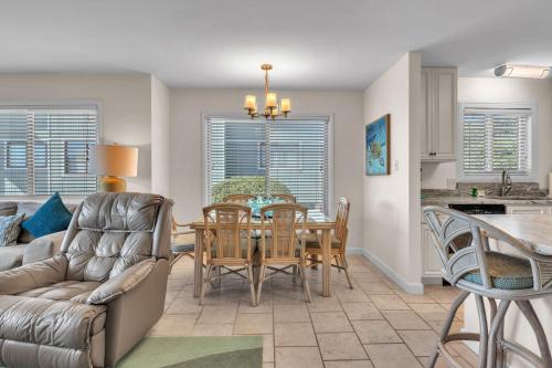 a kitchen and dining room with a table and chairs at #7 Ocean Court by Oak Island Accommodations in Caswell Beach