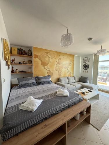 a bedroom with a large bed and a couch at Luxury Penthouse Studio with Outdoor Hot Tub and Panoramic Views in Sunny Beach