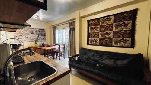 a kitchen with a sink and a couch in a room at Sumaq Hostel Backpackers in Buenos Aires