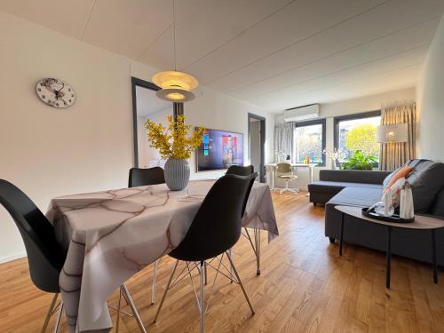 a dining room and living room with a table and chairs at Brand New Charming Nordic Home for 6 - Near Copenhagen in Farum