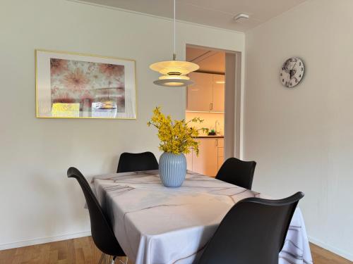a dining room table with a vase on top of it at Brand New Charming Nordic Home for 6 - Near Copenhagen in Farum