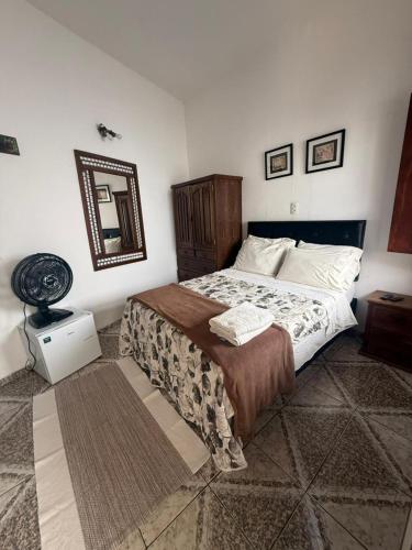 a bedroom with a bed and a mirror on the wall at Suítes da Praça Tiradentes in Tiradentes