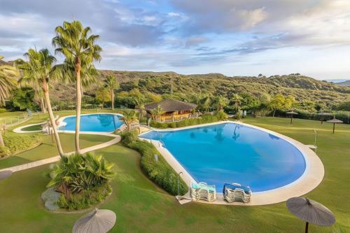 an overhead view of a swimming pool with palm trees at Parque Botanico Resort Country club in Estepona