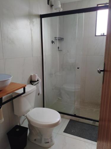 a bathroom with a shower with a toilet and a sink at Quintal da Gra in Araruama