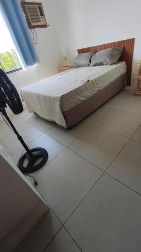 a bedroom with a bed on a tiled floor at Quintal da Gra in Araruama