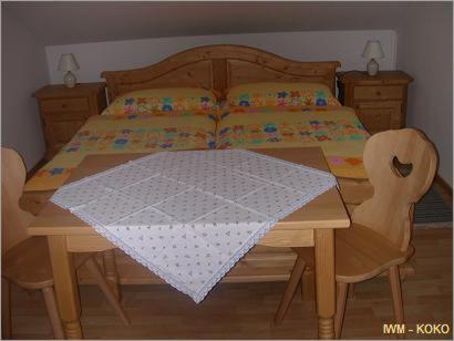 1 dormitorio con mesa de madera, 1 cama, mesa y sillas en Hanko Martina, en Litschau
