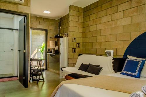 a bedroom with two beds and a table and a couch at Kazuo520 - Conforto e Minimalismo in Londrina