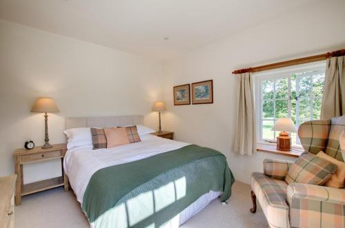 a bedroom with a bed and a couch and a window at 3 Bed in Carr Bank oc-gl128 in Beetham