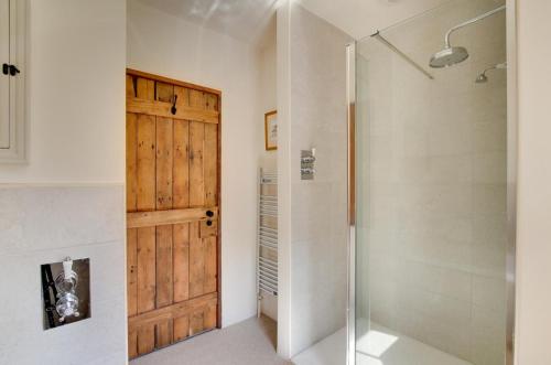 a bathroom with a shower and a wooden door at 3 Bed in Carr Bank oc-gl128 in Beetham