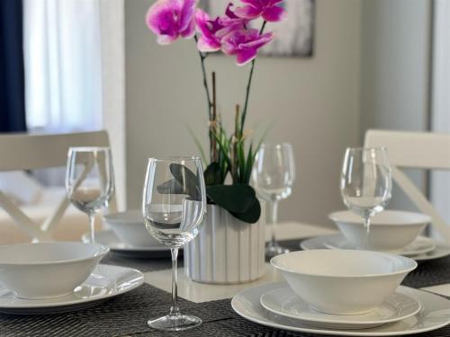 a table with wine glasses and a vase with purple flowers at 3315-Magic StudioCondo near Universal in Orlando