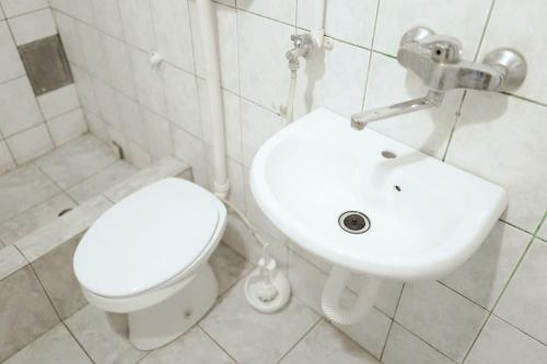 a white bathroom with a toilet and a sink at Oneone eleven hostel in Belgrade