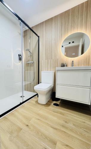 a bathroom with a toilet and a sink and a mirror at Sala 8 Gran Cinema in Sanlúcar de Barrameda