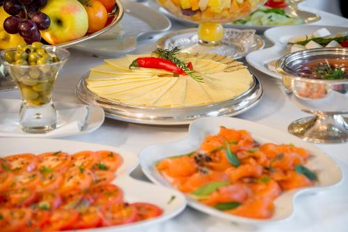 a table with plates of food and bowls of fruit at Grotthuss Boutique Hotel Vilnius in Vilnius