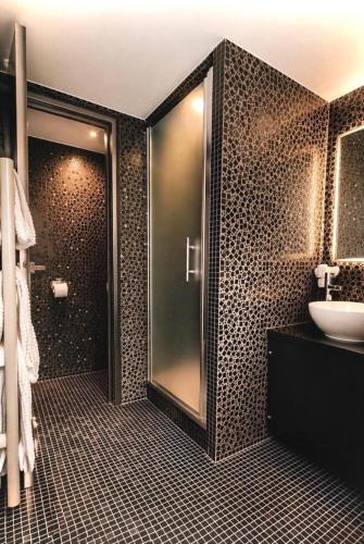 a bathroom with a glass shower and a sink at Hôtel Aero Paris Passy in Paris