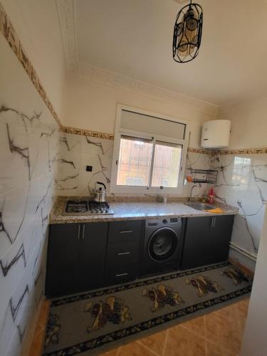 a kitchen with a washer and dryer at Errachidia Airport Apartment AC 15 Min Walk to Airport Gateway to Merzouga in Oulad el Haj