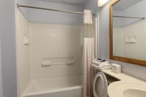 a bathroom with a sink and a toilet and a mirror at Classic Inn San Marcos, TX in San Marcos