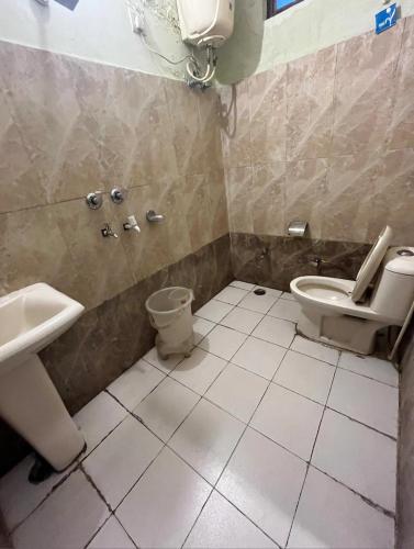 a bathroom with a toilet and a sink at Hotel Grand Inn in Haridwār