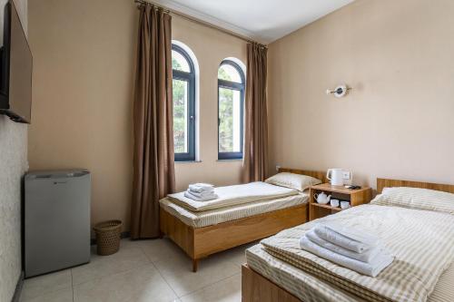 a room with two twin beds and two windows at Olchazor hotel in Tashkent